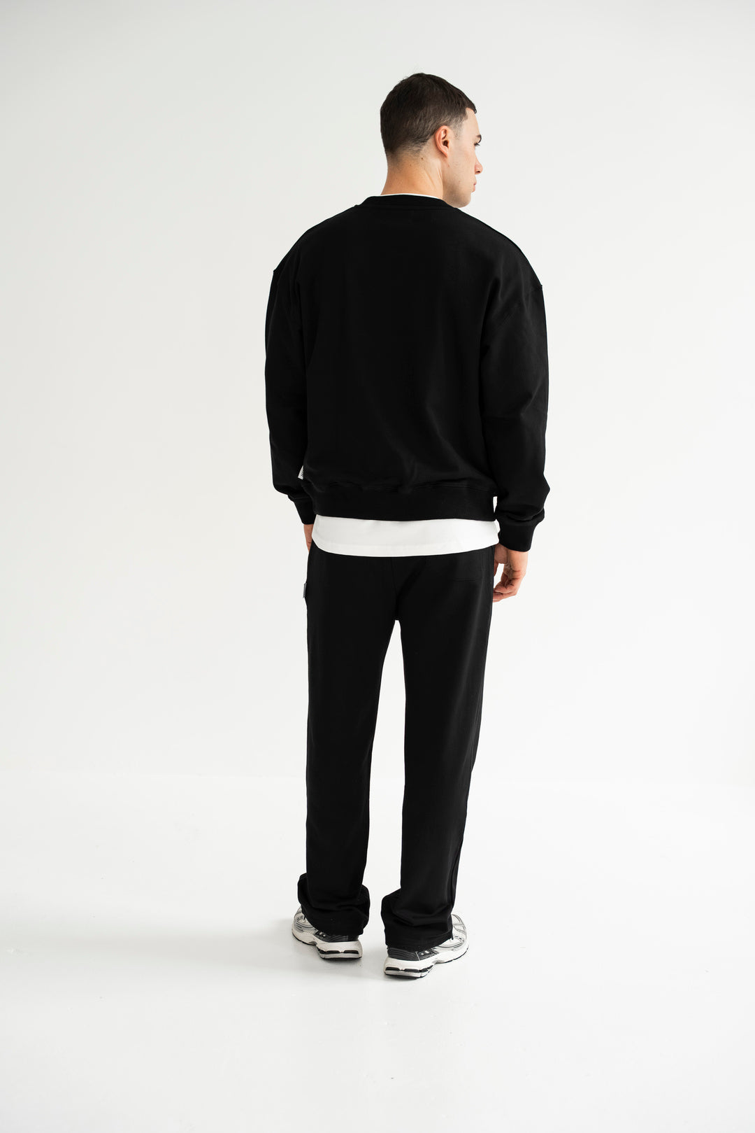 Man wearing a black tracksuit on a white background